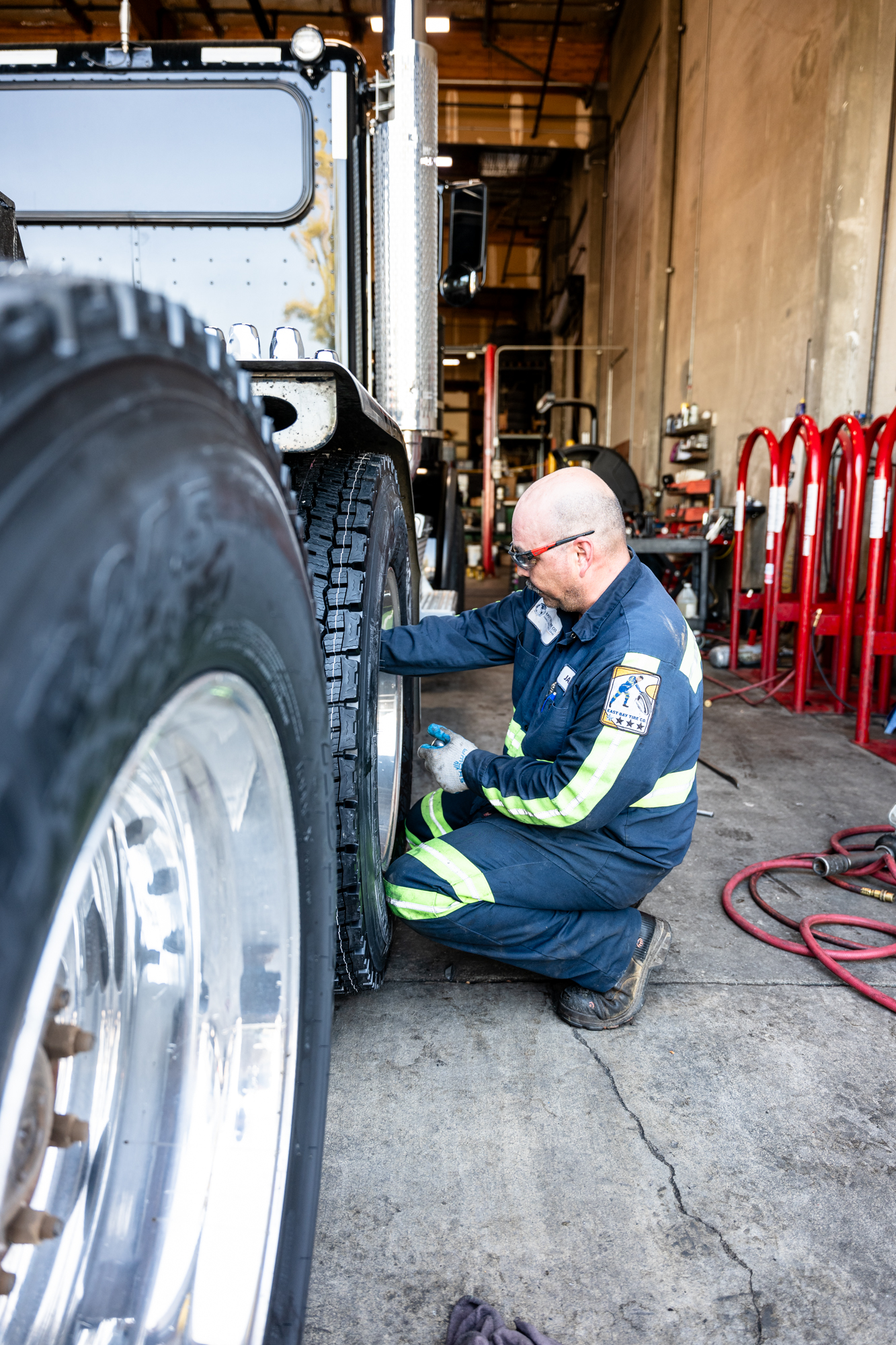 Empleado de East Bay Tire trabajando en la rueda de un camión