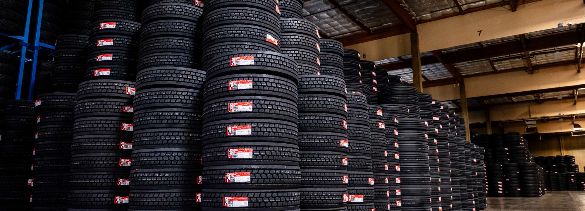 Stacks of large OTR tires sit in a East Bay Tire facility