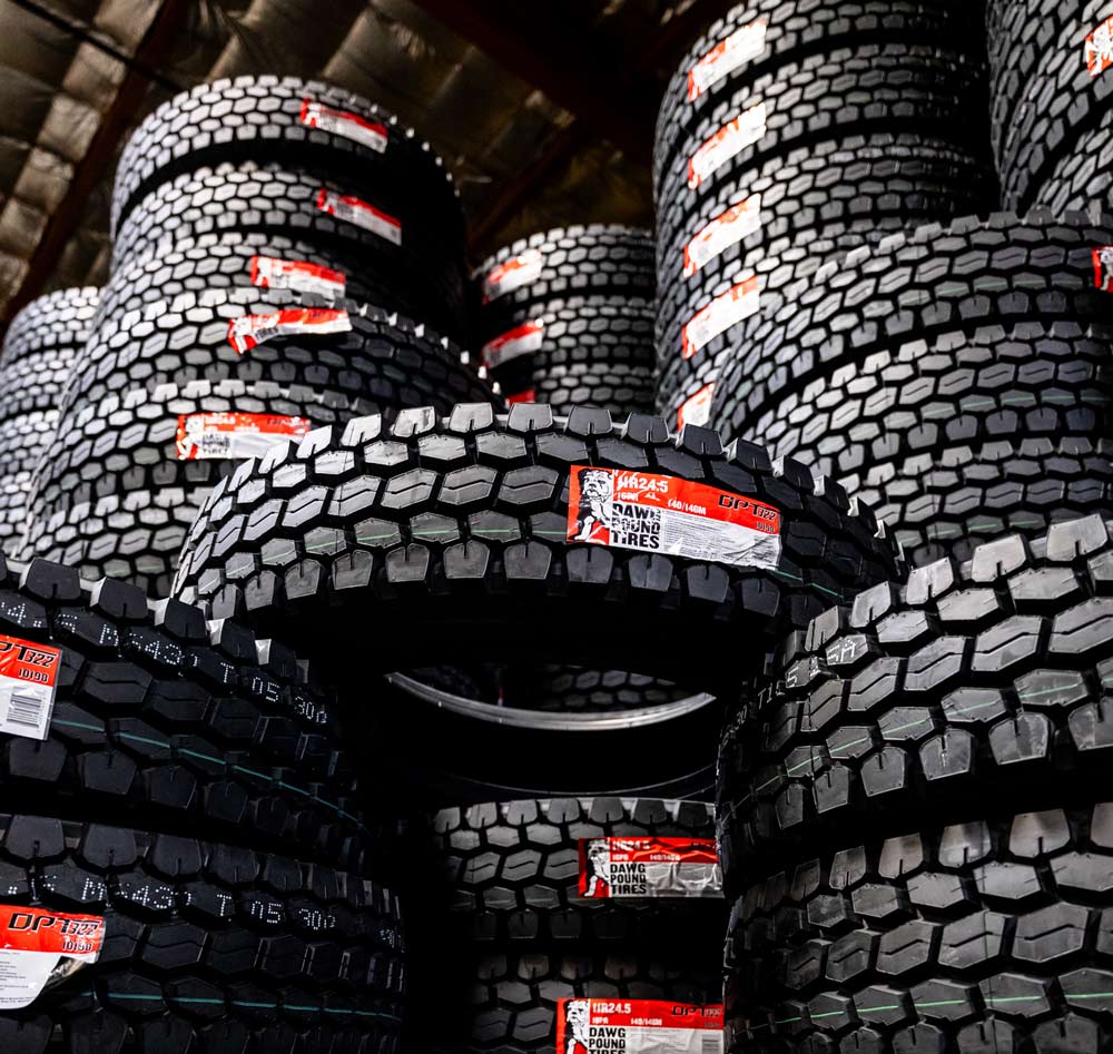Stacks of large OTR tires sit in a East Bay Tire facility.