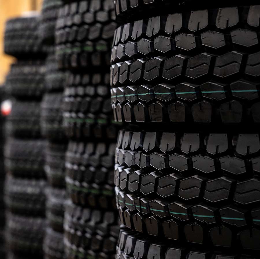Stacks of large OTR tires sit in a East Bay Tire facility